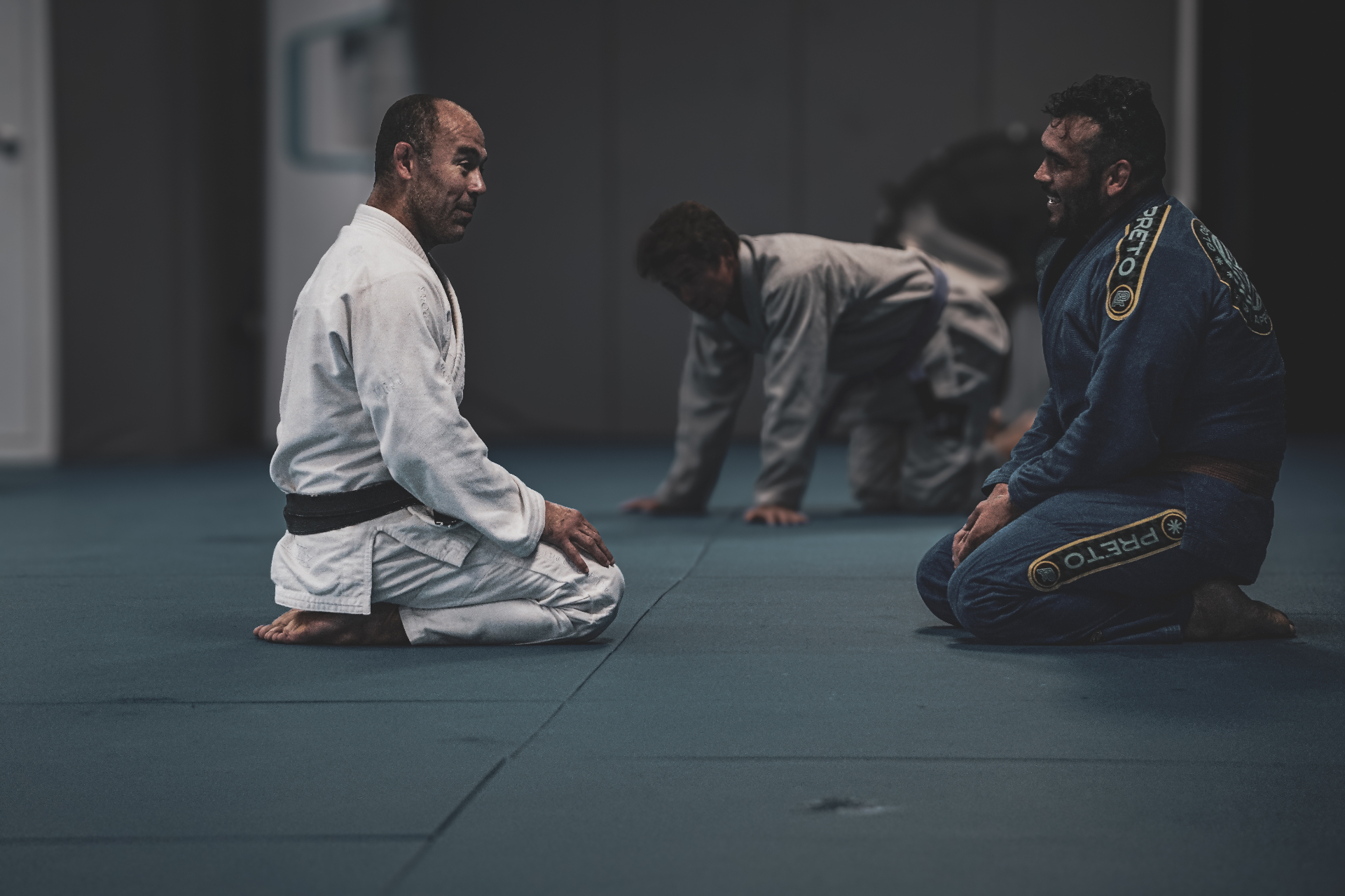 Marcelo Garcia and Manuel Morales kneeling on the mats between rounds